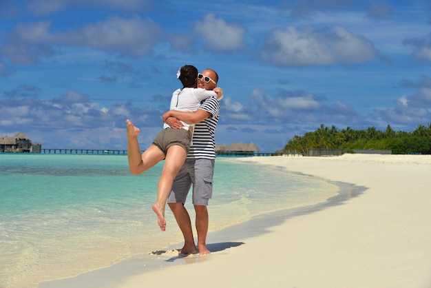 heureux jeune couple s'amuser et se détendre pendant les vacances d'été sur fond lieu de voyage aux maldives et belle plage de sable blanc