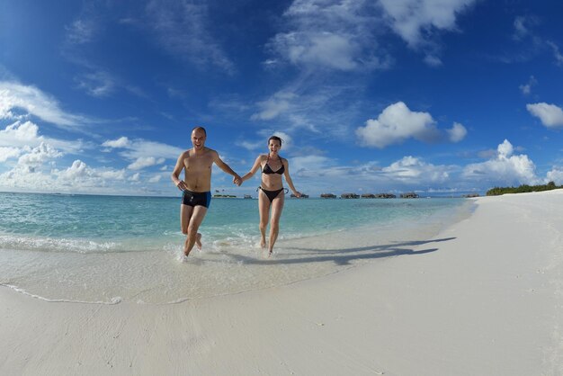 heureux jeune couple s'amuser et se détendre pendant les vacances d'été sur fond lieu de voyage aux maldives et belle plage de sable blanc