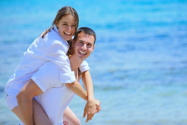 heureux jeune couple s'amuser et se détendre sur la plage