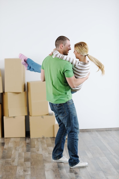 Heureux jeune couple se déplaçant dans une nouvelle maison