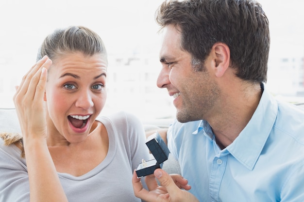 Heureux jeune couple se fiancer sur le canapé