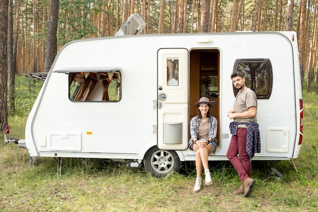 Heureux jeune couple se reposer par maison sur roues