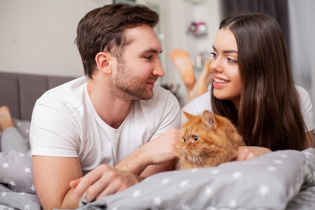 Photo heureux jeune couple sensuel couché dans son lit ensemble.