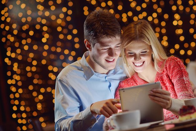 heureux jeune couple avec une tablette au restaurant