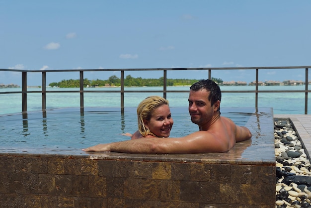 heureux jeune couple en vacances d'été s'amuser et se détendre lors d'une belle journée ensoleillée sur la plage