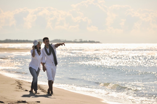 heureux jeune couple en vêtements blancs avoir des loisirs romantiques et s'amuser sur la belle plage en vacances