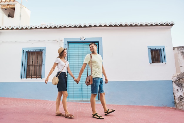 Heureux jeune couple de voyageurs marchant