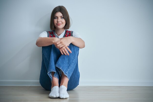 heureux jeune étudiant positif posant sur fond clair