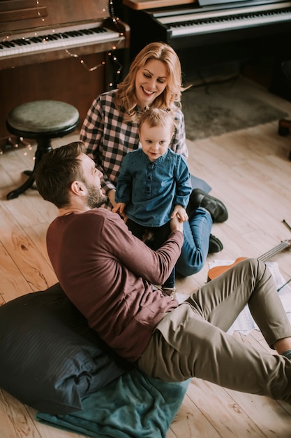 Heureux jeune famille jouant sur le sol dans la chambre