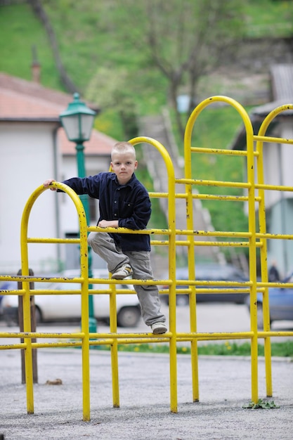 heureux jeune garçon enfant blond s'amuser et jouer à des jeux en plein air dans le parc