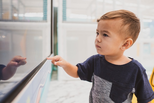 Heureux jeune garçon enfant jouant dans l'aire de jeux intérieure