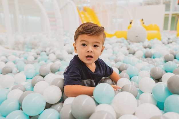 Heureux jeune garçon enfant jouant dans l'aire de jeux intérieure