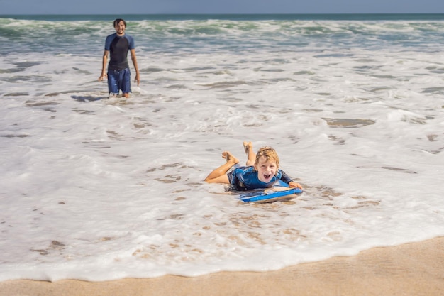 Heureux jeune garçon s'amusant à la plage en vacances avec Boogie board