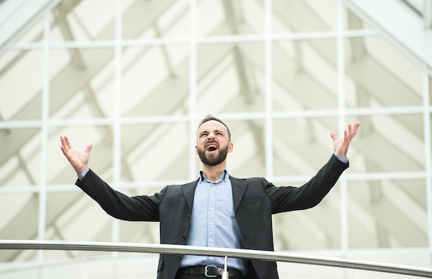 Heureux jeune homme d'affaires au travail dans les bureaux modernes.