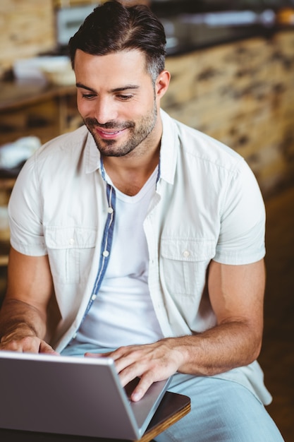 Heureux jeune homme d&#39;affaires travaillant à ordinateur portable, boire du café