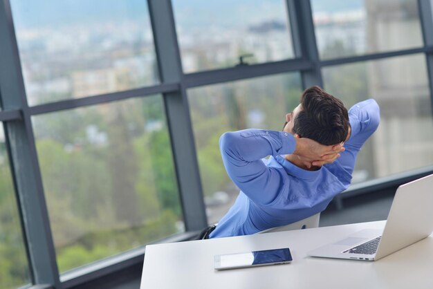 heureux jeune homme d'affaires travaille dans un bureau moderne sur ordinateur