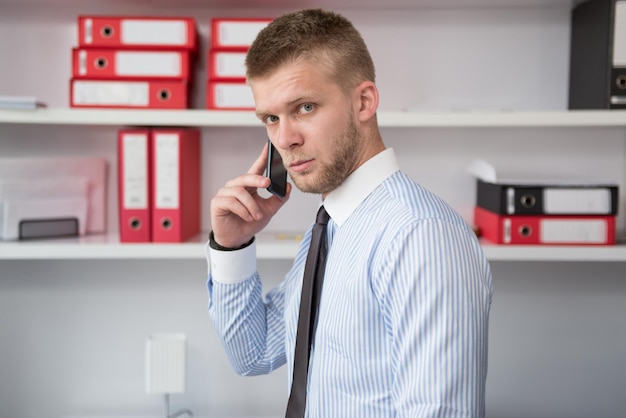 Heureux jeune homme d'affaires travaille dans un bureau moderne sur ordinateur