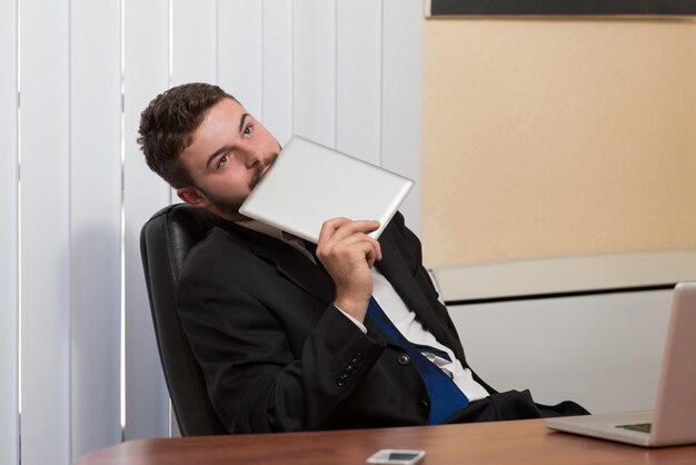 Heureux jeune homme d'affaires travaille dans un bureau moderne sur ordinateur