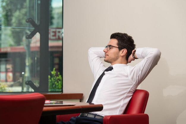 Heureux jeune homme d'affaires travaille dans un bureau moderne sur ordinateur