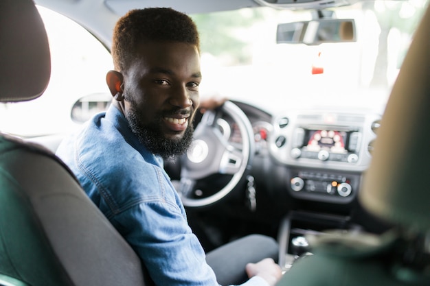 Photo heureux jeune homme afro-américain au volant d'une voiture