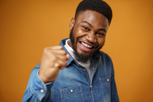 Heureux jeune homme afro-américain excité célébrant le succès