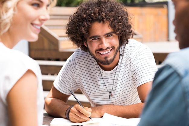 Heureux jeune homme appréciant avec des amis après l'étude