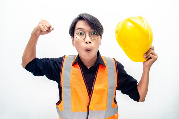 Heureux jeune homme asiatique ouvrier du bâtiment, ingénieur, constructeur levant les poings en faisant le geste oui
