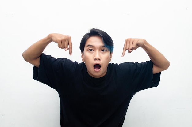 heureux jeune homme asiatique séduisant en peek a boo cheveux bleus pointant, promouvant et faisant la publicité de produits