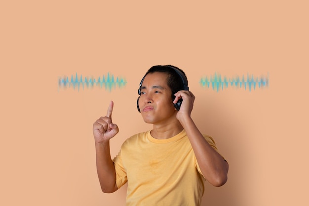 Heureux jeune homme au casque écoutant de la musique et dansant avec des ondes sonores