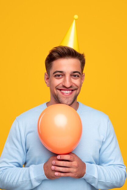 Heureux jeune homme avec ballon célébrant les vacances