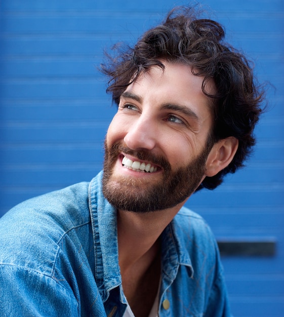 Heureux jeune homme avec une barbe en souriant