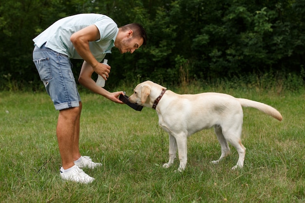 Heureux jeune homme buvant un chien Labrador