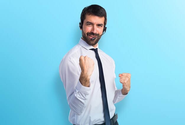 Heureux jeune homme avec un casque sur fond coloré