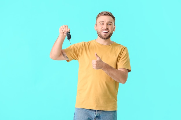 Heureux Jeune Homme Avec Clé De Voiture Sur Fond De Couleur