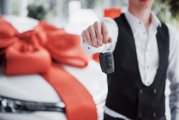 Heureux jeune homme avec des clés dans ses mains, chanceux acheter une voiture