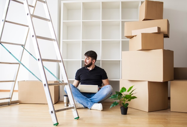 Heureux jeune homme déménageant dans une nouvelle maison