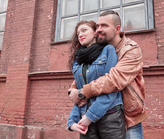 heureux jeune homme embrasse sa petite amie dans une rue de la ville. histoire d'amour