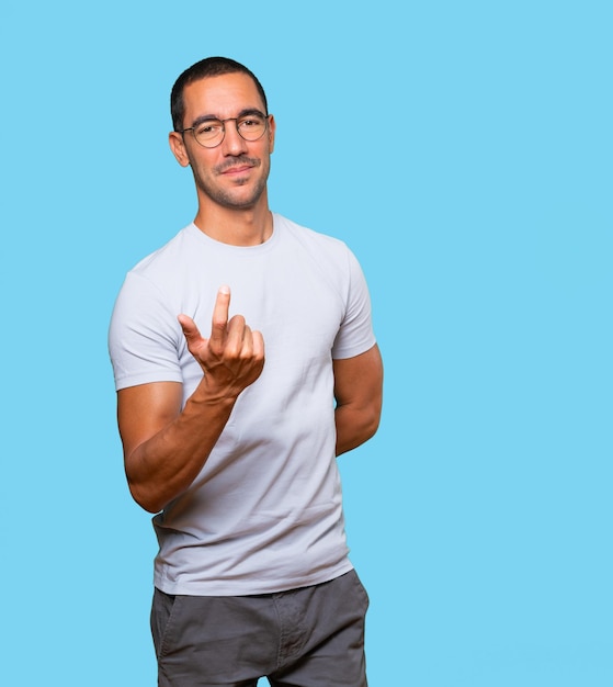 Heureux jeune homme faisant un geste de bienvenue avec sa main