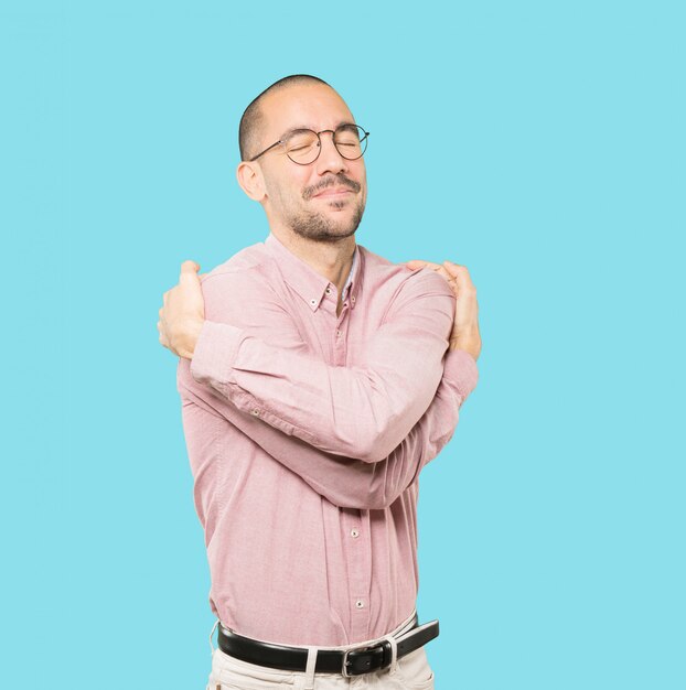 Heureux jeune homme faisant un geste de câlin