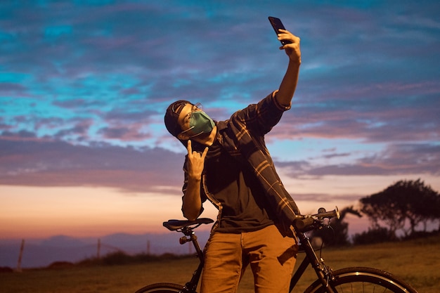 heureux jeune homme faisant selfie à côté de son vélo