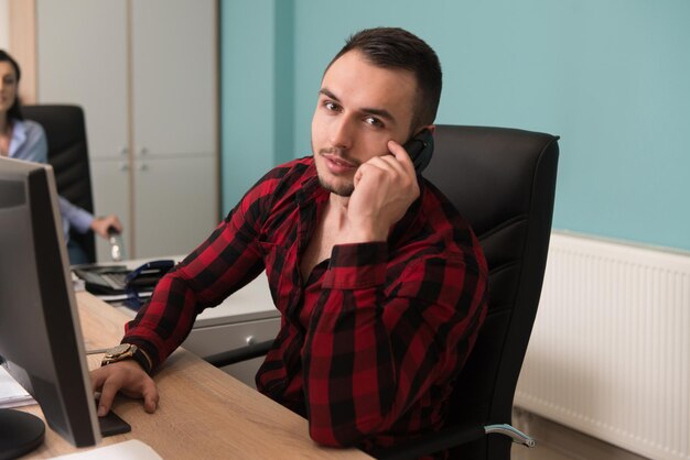 Heureux jeune homme et femme d'affaires travaillent dans un bureau moderne sur ordinateur