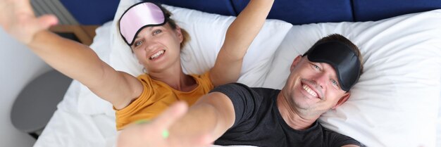 Heureux jeune homme et femme allongés sur le lit concept de sommeil confortable et réparateur