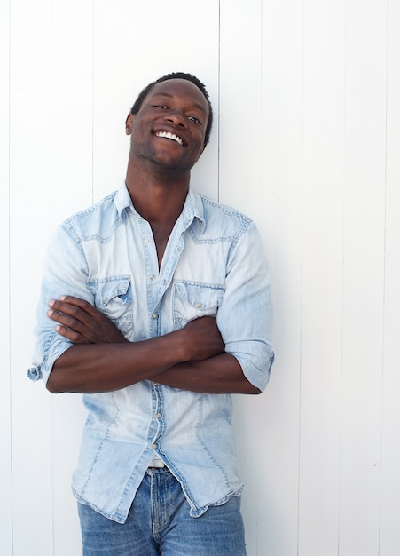 Heureux jeune homme noir souriant à l&#39;extérieur sur fond blanc