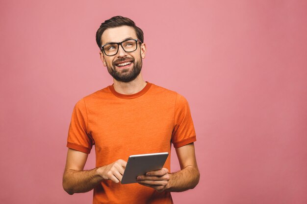 Heureux jeune homme en position décontractée et à l'aide de tablette