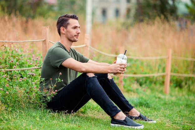 Heureux jeune homme urbain avec livre en plein air