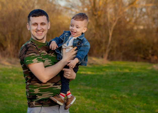 Heureux jeune père jouant avec son fils à l'extérieur