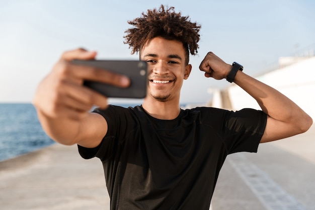 Heureux jeune sportif à la plage