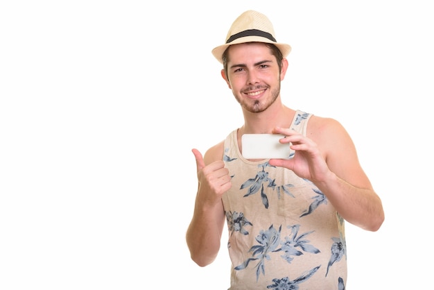 Heureux jeune touriste barbu homme prenant une photo avec un téléphone prêt pour les vacances