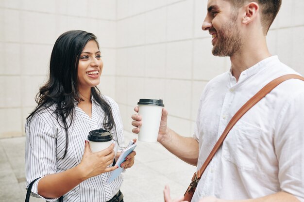 Heureux les jeunes gens d'affaires discutant des nouvelles et des potins pendant la pause-café