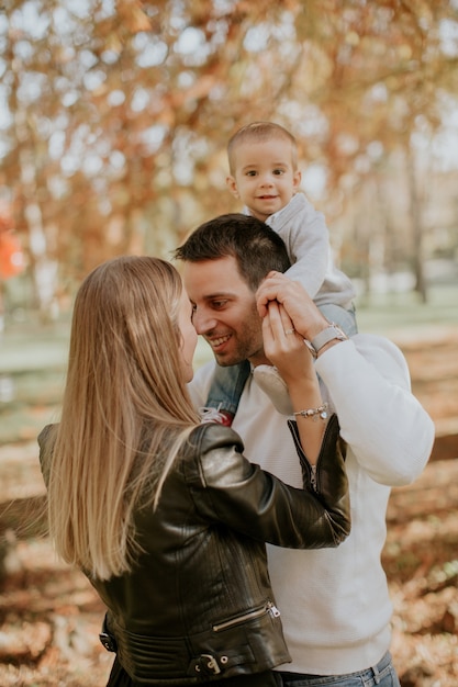 Heureux jeunes parents avec bébé garçon en automne parc